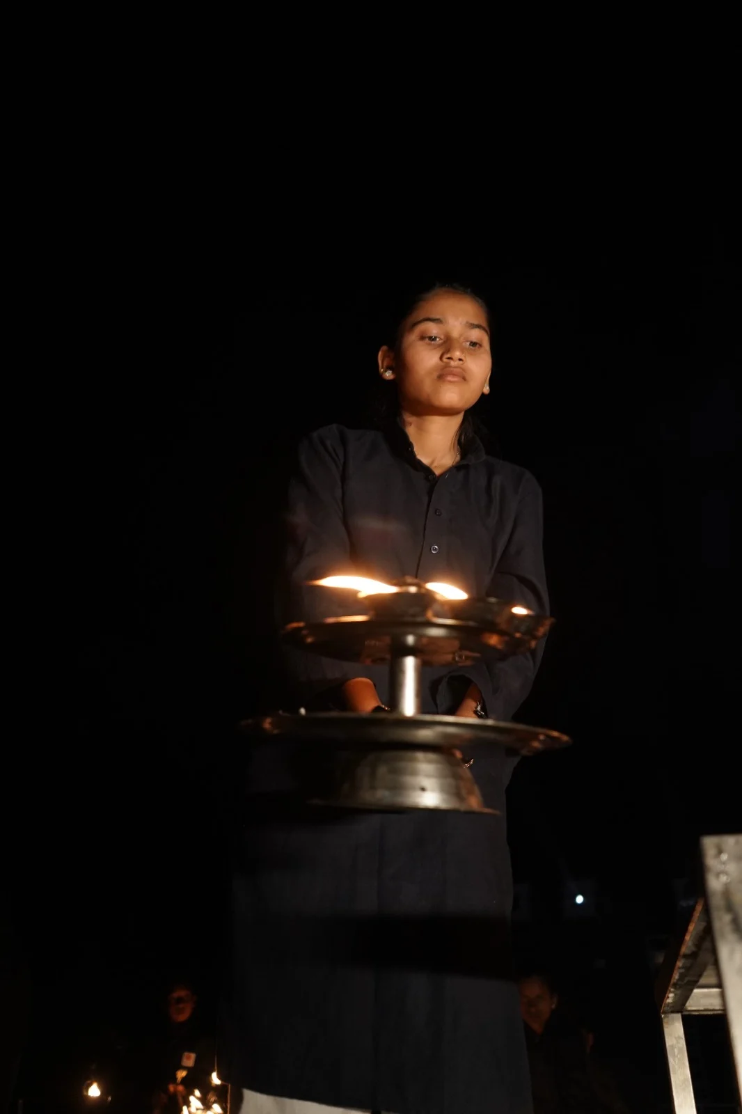 Young child holding a lit brass oil lamp
