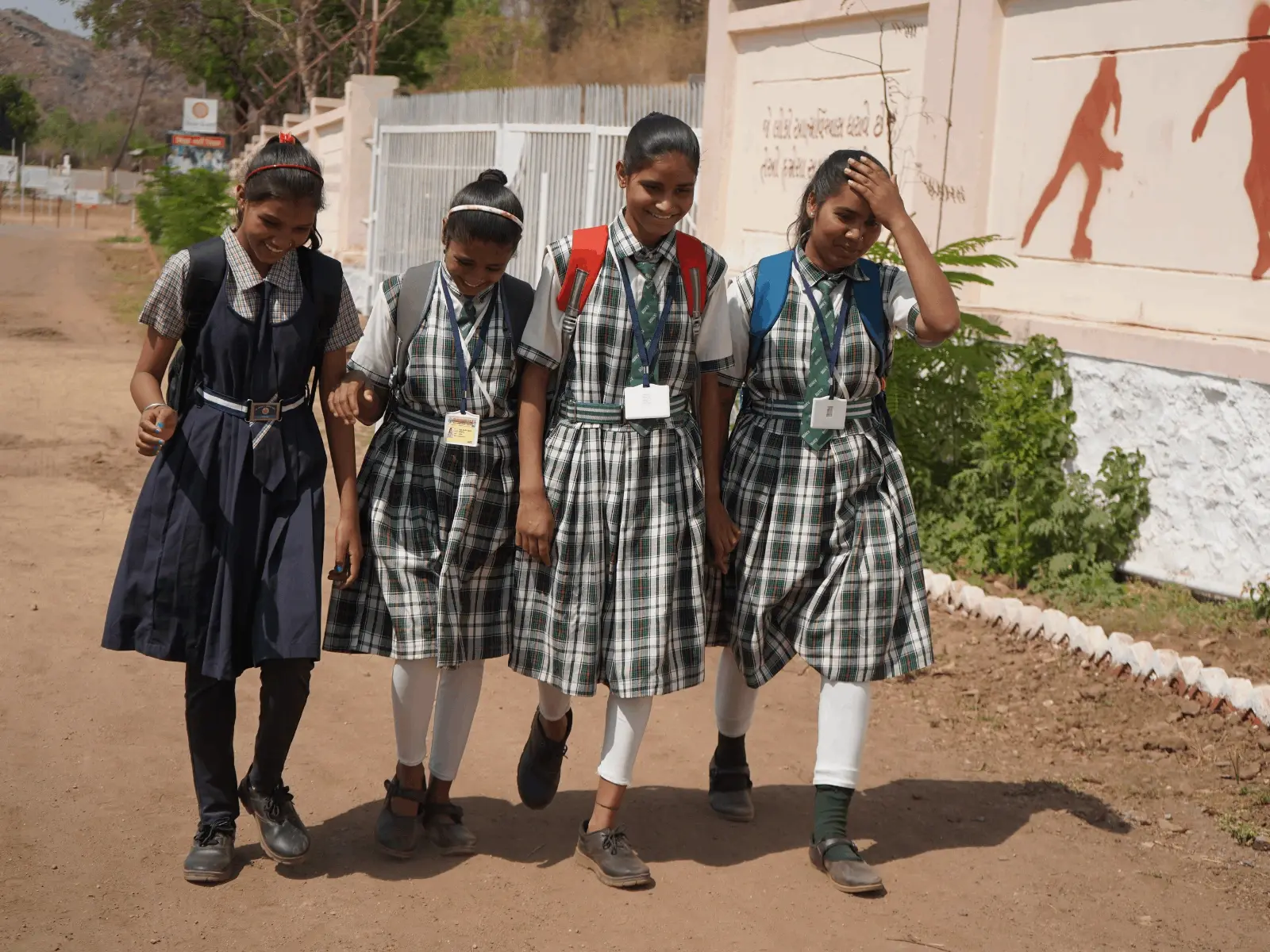 A group of students in school uniforms walking down the steps of a school building.