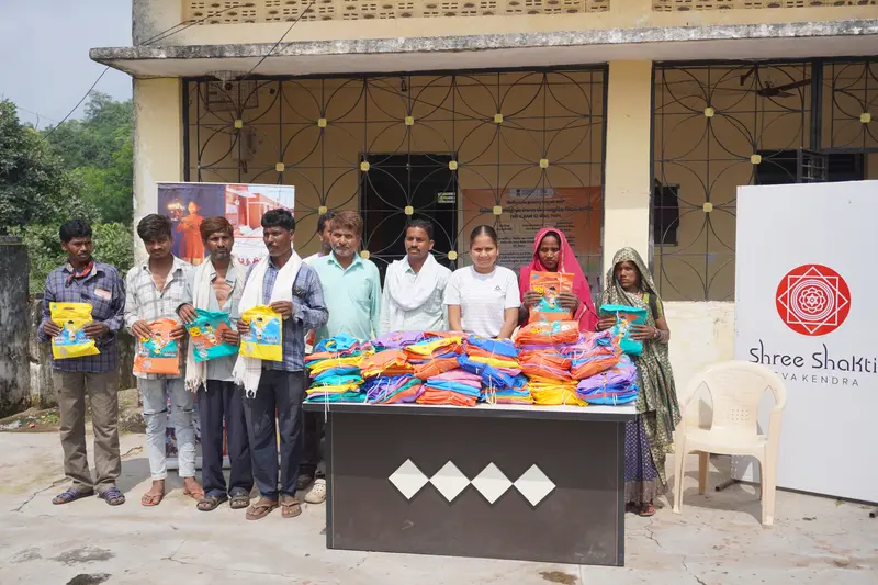 Tribal families receiving raincoats at Pancha Village, Ambaji - SSSK distribution drive