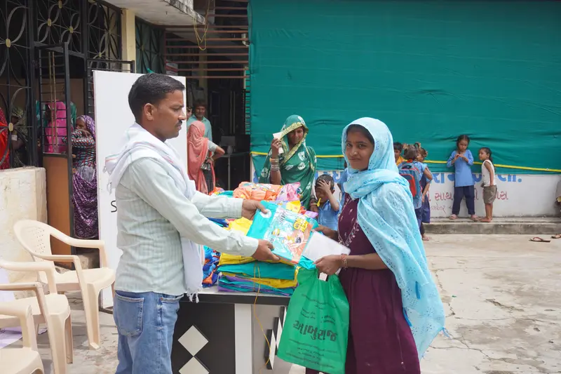 Tribal families with new raincoats after distribution drive in Pancha Village
