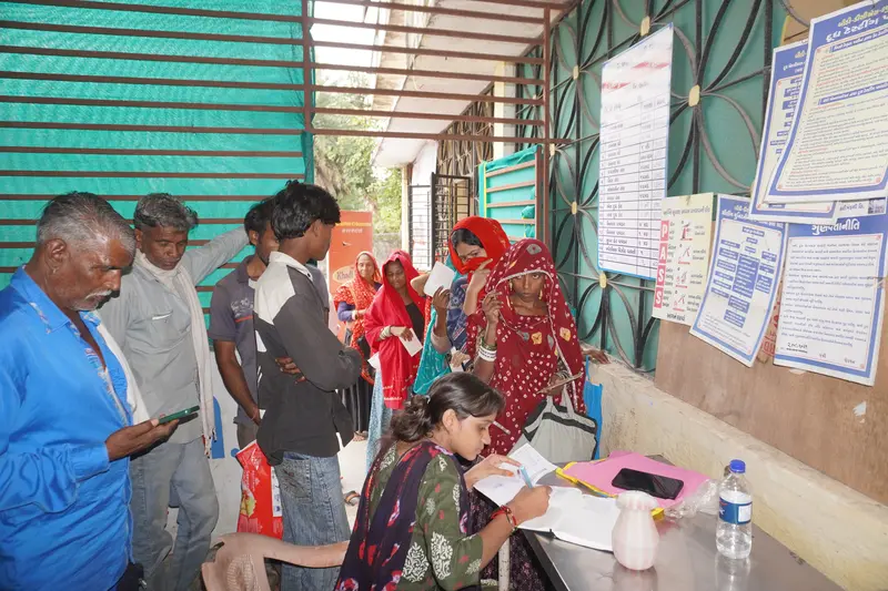 Smiling community members after receiving raincoats from SSSK in Pancha Village