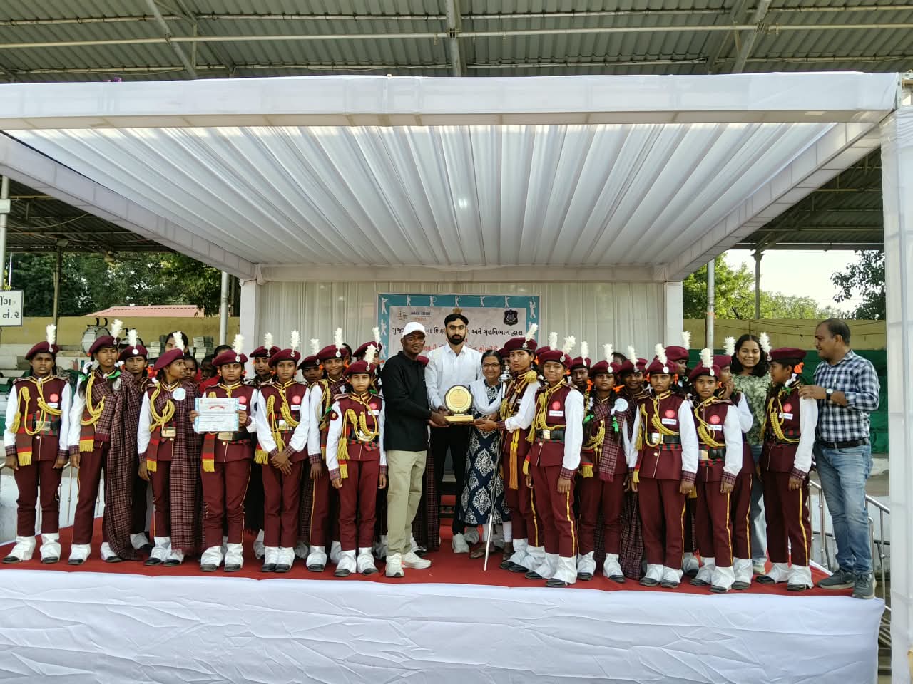 Students representing Shree Shakti Seva Kendra, Ambaji, gather with their award during the state-level school band competition, celebrating their hard work, teamwork and achievement.